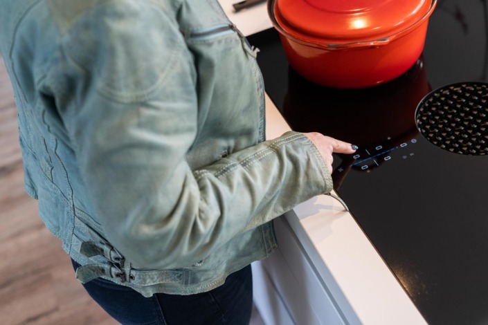 detailfoto van inductieplaat in witte designkeuken